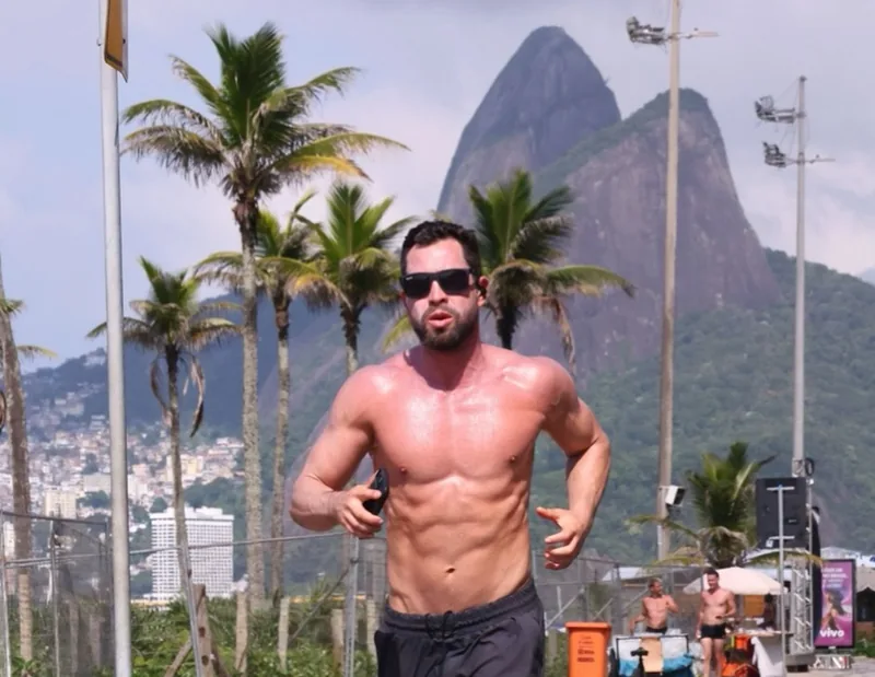 Rodolfo correndo na orla com o Morro Dois Irmãos ao fundo